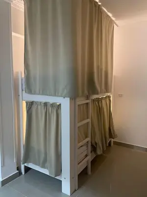 a bed in a room with a curtain at Serafy City Center Hostel for Foreigners Adults Only in Hurghada