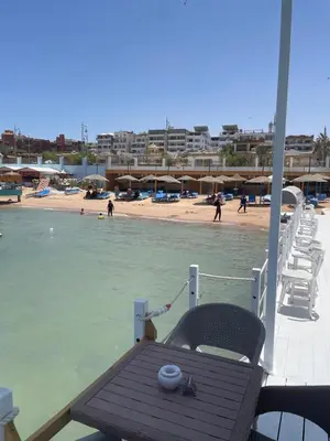a boat with a table and chairs on a beach at Lilly Stays Sheraton Road in Hurghada