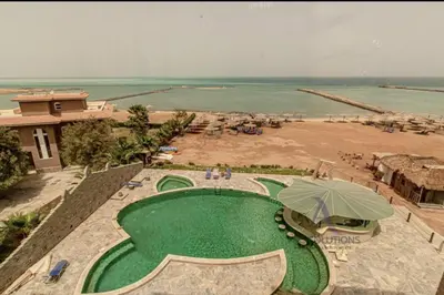 a resort with a green swimming pool next to a beach at Apartment - Sleeps 4 - Pool - Pet friendly in Hurghada