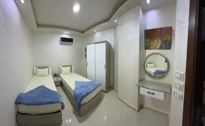 a small room with two beds and a mirror at Casablanca Beach Direct sea view Tow Bedroom Apartment in Hurghada