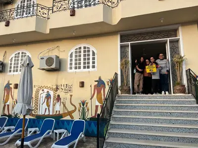 a group of people standing outside of a building at Royal Mountain in Luxor