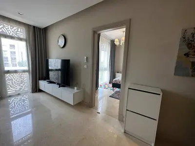 a living room with a television and a door to a room at Mangroovy Tasteful 1 bedroom in Hurghada