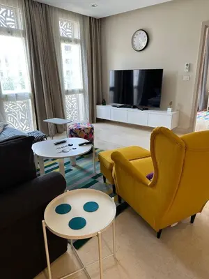 a living room with a couch and chairs and a tv at Mangroovy Tasteful 1 bedroom in Hurghada