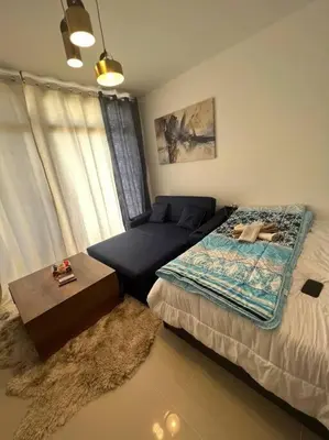 a bedroom with a bed and a couch at Brand new studio at G-Cribs ElGouna in Hurghada