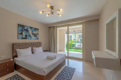 a bedroom with a large bed and a window at Cozy 1-Bedroom Apartment in Mangroovy, El Gouna. Private terrace, garden and pool access in Hurghada
