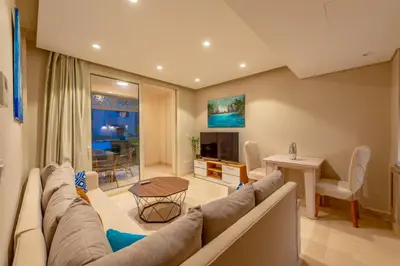a living room with a couch and a table at Cozy 1-Bedroom Apartment in Mangroovy, El Gouna. Private terrace, garden and pool access in Hurghada