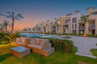 a resort yard with a couch and a pool at Cozy 1-Bedroom Apartment in Mangroovy, El Gouna. Private terrace, garden and pool access in Hurghada