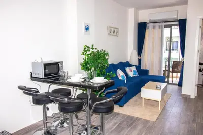 a living room with a blue couch and a table at 2 Bed Resort Apartment - Sleeps 4 - Hotel Services in Hurghada