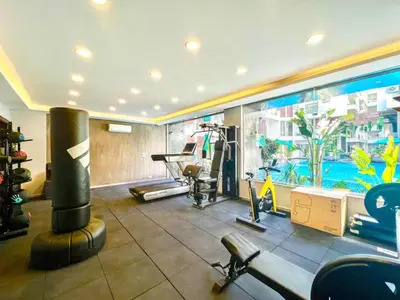 a gym with cardio equipment and a swimming pool at 2 Bed Resort Apartment - Sleeps 4 - Hotel Services in Hurghada
