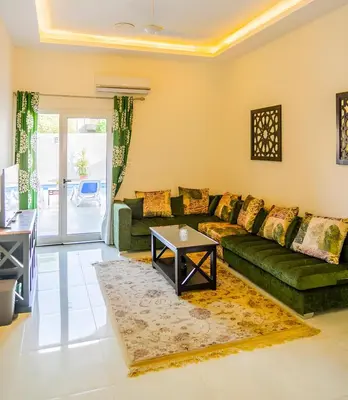 a living room with a green couch and a table at Royal Home Luxor Pool View in Luxor