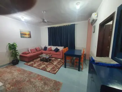 a living room with a red couch and a table at Abeer Suites 3 basement in Hurghada