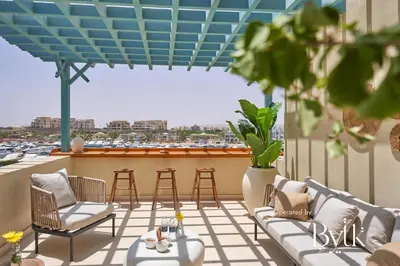 a rooftop patio with chairs and tables and a view of a harbor at BYTK - La Veranda in Hurghada