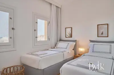 two beds in a room with two windows at BYTK - La Veranda in Hurghada