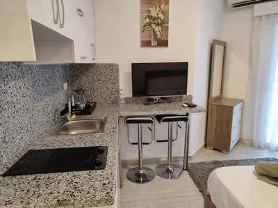 a kitchen with a sink and a tv in a room at A Superb Studio Apartment in Hurghada