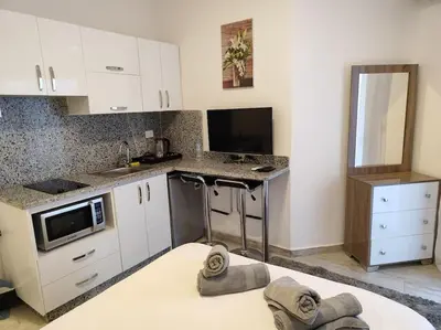 a kitchen with white cabinets and a counter top at A Superb Studio Apartment in Hurghada
