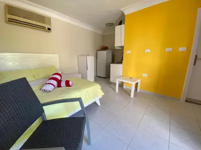 a living room with a bed and a yellow wall at Moubark 6 Directly to the swimming pool in Hurghada