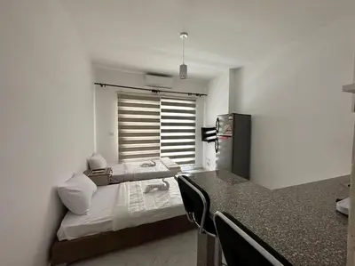 a room with a kitchen with a table and a refrigerator at Уютное место рядом с променадом in Hurghada