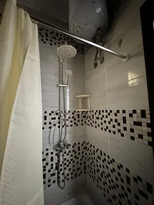 a shower in a bathroom with a tub at Уютное место рядом с променадом in Hurghada