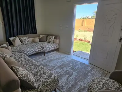 a living room with couches and a door to a yard at Moon Adam hostel in ‘Ezbet Abu Ḥabashi