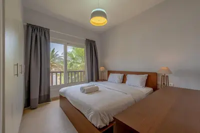 a bedroom with a large bed and a window at Peaceful 2-Bedroom in Waterside, El Gouna. Pool & Lagoon in Hurghada