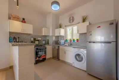 a kitchen with a refrigerator and a washing machine at Peaceful 2-Bedroom in Waterside, El Gouna. Pool & Lagoon in Hurghada