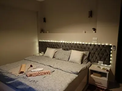 a bedroom with a bed with lights on it at WestLuxApartment in Al Karnak