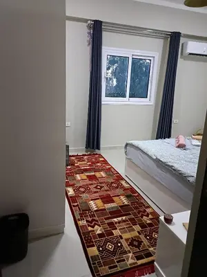 a bedroom with a bed and a rug at WestLuxApartment in Al Karnak