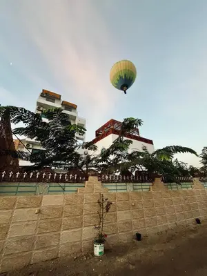 a hot air balloon flying over a brick wall at Flower Of Life Hotel in Luxor