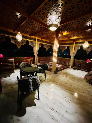 a room with a table and chairs and a chandelier at Flower Of Life Hotel in Luxor