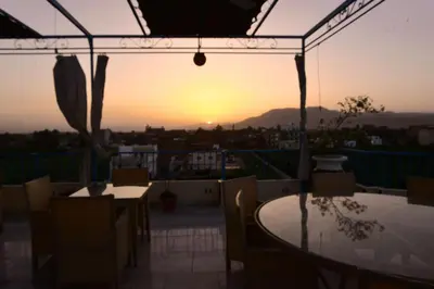a patio with tables and chairs and the sunset at Flamingo Boutique hotels in Luxor