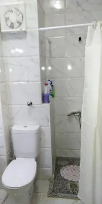 a white bathroom with a toilet and a shower at منتجع طيبة فيو Tiba view in Hurghada