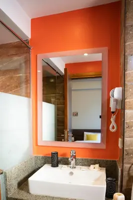 an orange bathroom with a sink and a mirror at Al Dora Residence Suites Hurghada in Hurghada