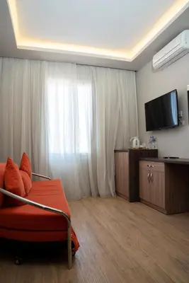 a hotel room with a red couch and a television at Al Dora Residence Suites Hurghada in Hurghada