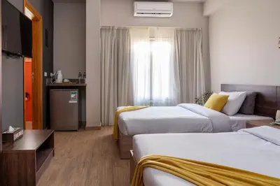 a hotel room with two beds and a television at Al Dora Residence Suites Hurghada in Hurghada