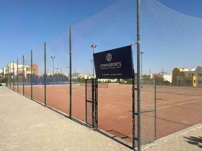 a fence on a tennis court with a sign on it at Hurghada Makadi Heights in Hurghada