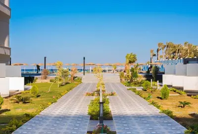 a walkway in the middle of a building with trees at Scandic Resort - Mido Chalet in Hurghada
