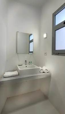 a white bathroom with a sink and a mirror at New! Lovely 1BR in Swan Lake, Gouna. Azure Lagoon in Hurghada
