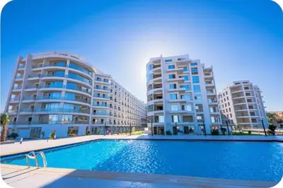 a swimming pool in front of two tall buildings at شاليه السعادة in Hurghada