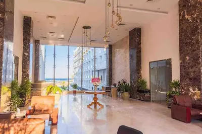 a large lobby with chairs and a table and large windows at شاليه السعادة in Hurghada
