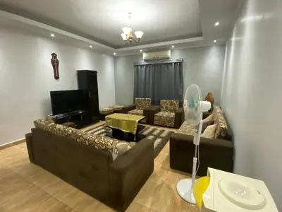 a living room with two couches and a tv at Amwaj Compound in Hurghada