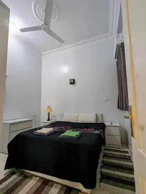 a bedroom with a bed and a ceiling fan at Villa Rebecca in Luxor