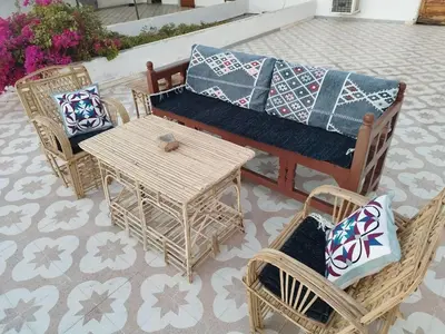 a patio with a couch and chairs and a table at Gabawy Garden Ferienwohnung in Luxor