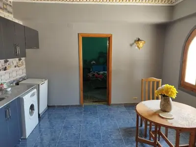 a kitchen with a table and a laundry room at Gabawy Garden Ferienwohnung in Luxor