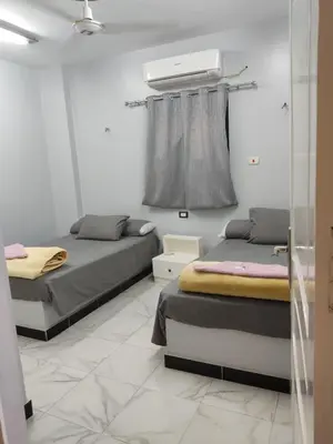 two beds in a room with a window at Hamo Fathy Nubian House in Aswan