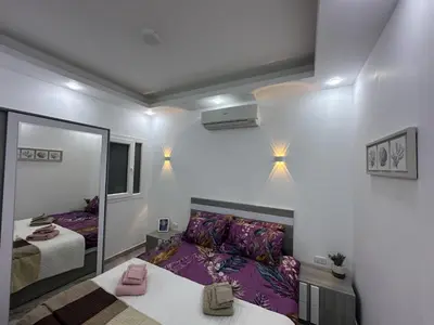 a small room with a bed and a mirror at 2 Bed Flat - Sleeps 6 - Pool - Parking - Wifi in Hurghada