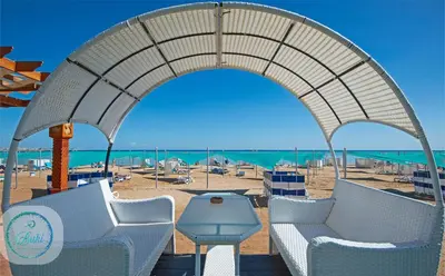a view of a beach with chairs and a table at Sea View at Gravity Sahl Hasheesh 7 Pools & Beach-FOR GUESTS WITH NONEGYPTIAN PASSPORTS in Hurghada