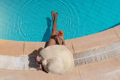 a woman laying on the side of a swimming pool at Lemon & Soul Makadi Garden in Hurghada