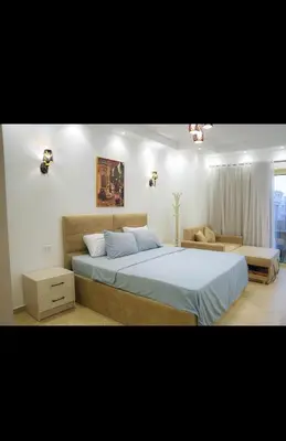 a bedroom with a large bed and a couch at Benashti Hurghada apartment in Hurghada