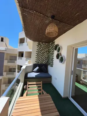 a balcony of a apartment with a bed and a door at Benashti Hurghada apartment in Hurghada