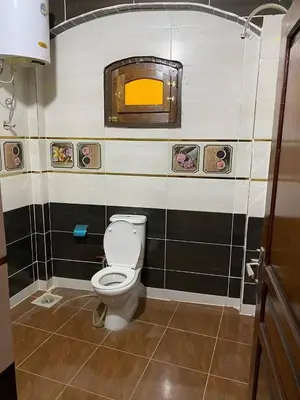 a bathroom with a toilet and a window on the wall at Malika nubian house in Aswan